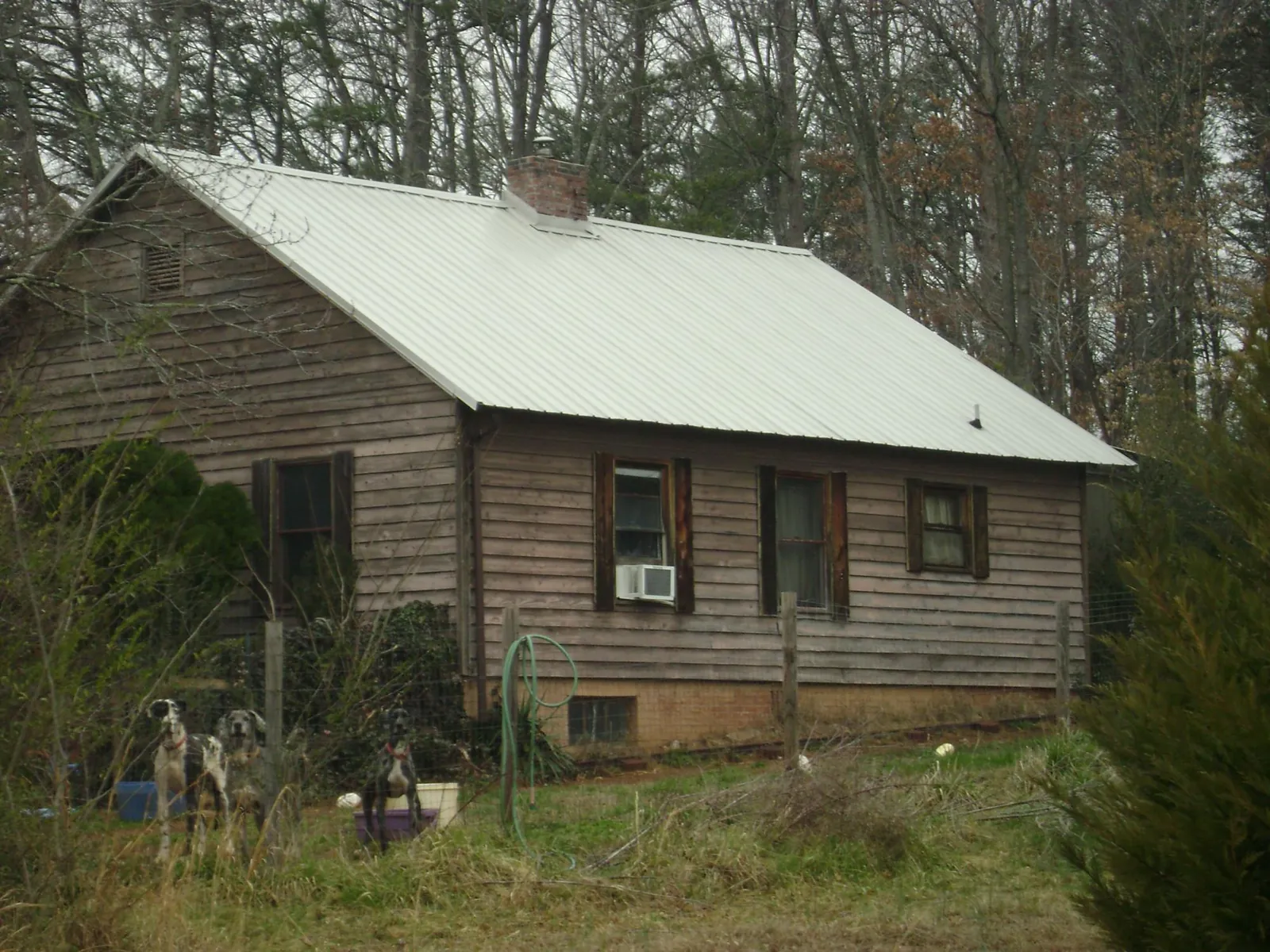 White metal roof on an old wood sided farmhouse, from a Asphalt Shingle Roof Repair job in Fairhope